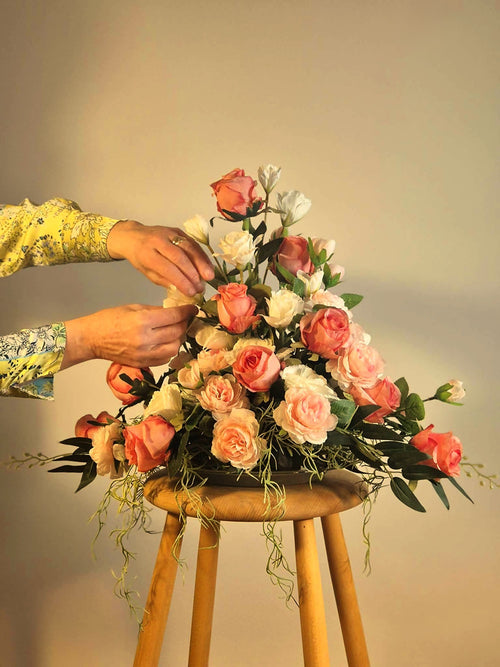 Eksklusiv rosen-blomsterdekoration på en pædastal, der skaber en hyggelig og luksuriøs lounge stemning.