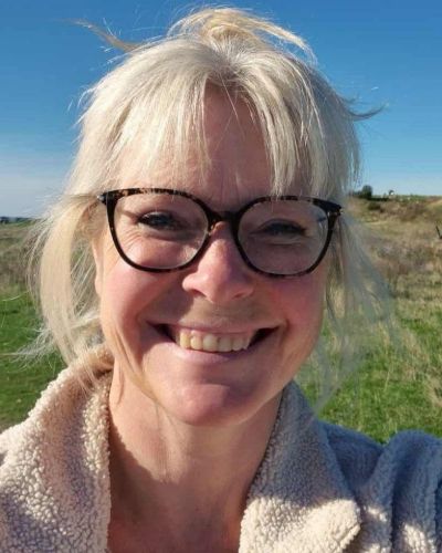 Linda smiler udendørs på en solskinsdag